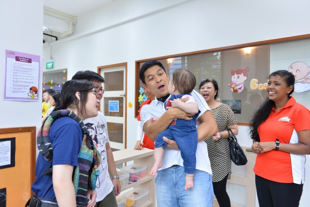Minister sharing a moment with infant Cara Low from the Ping Yi Greens centre, accompanied by her parents, Director Dr Jane Ching-Kwan and centre Principal Ms Diana Elizabeth.