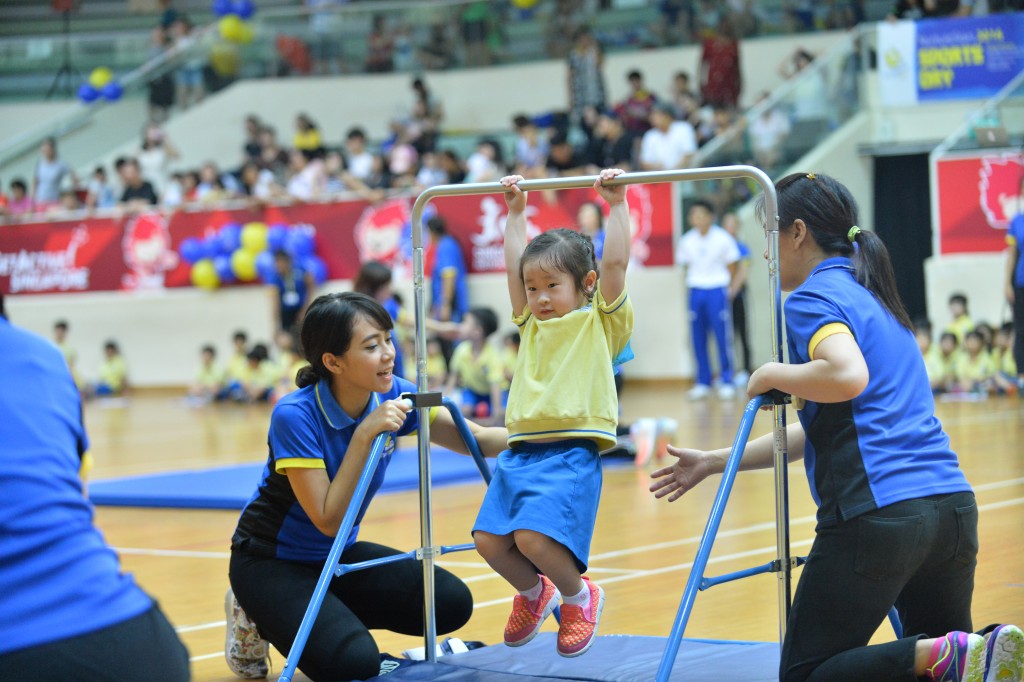 A child showcased her strengths at the ‘hanging bar’ station, under the watchful eyes of 2 teachers.
